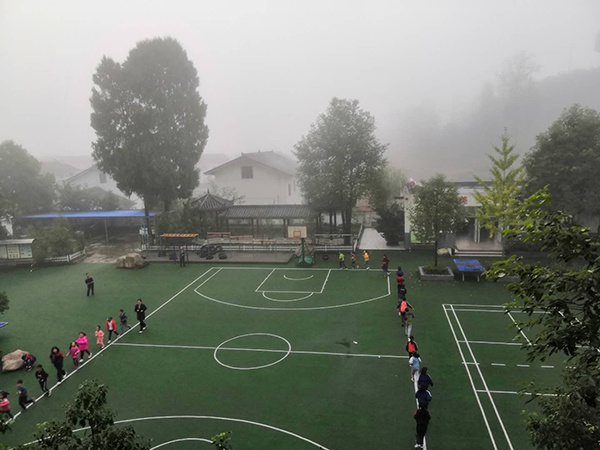  10月中旬的一个清晨，山间萦绕着雾气，孩子们围着操场在跑步。