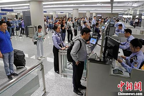 资料图：上海虹桥国际机场T1航站楼内入境大厅，民警正在为旅客办理通关手续。</p><p>中新社记者 殷立勤 摄