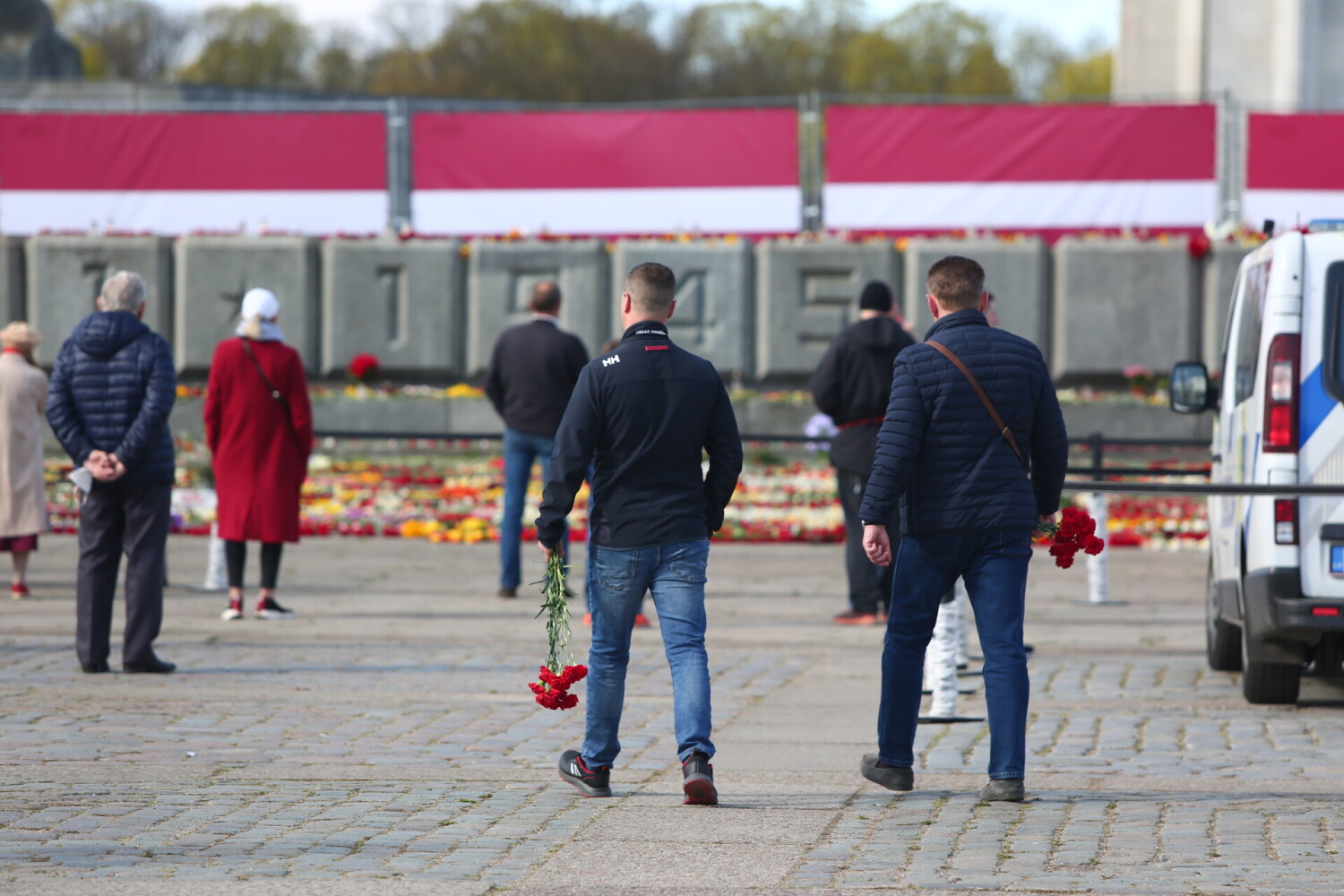 苏联纪念碑前的鲜花被铲走后，拉脱维亚民众又给摆满