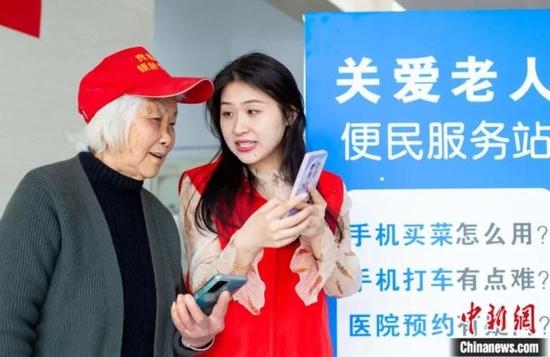 在江苏省海安市大公镇便民服务中心开设的老年人手机公益课堂上，志愿者指导老年人如何使用智能手机。翟慧勇 摄