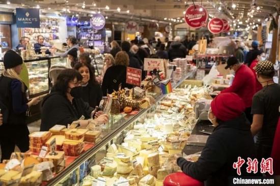 2022年冬季，顾客在纽约中央车站市场询问奶酪价格。美国在当年遭遇了40年来最严重的通货膨胀。消费者价格指数（CPI）同比涨幅在6月达到9.1%的峰值后，一直保持在7%以上的高位，持续“高烧”的通胀令经济承压。廖攀 摄