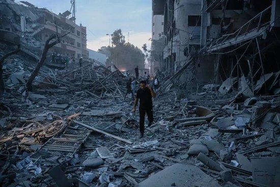  10月7日，巴勒斯坦民众在加沙城查看以色列空袭后毁坏的民宅 / 图源：新华社