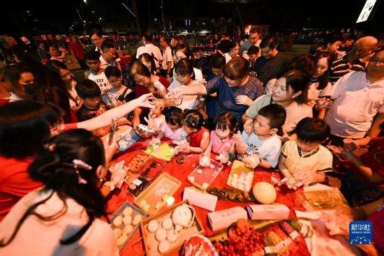  9月27日，在马来西亚马六甲州丹绒吉宁举办的中秋晚会上，人们参加制作月饼活动图：新华社