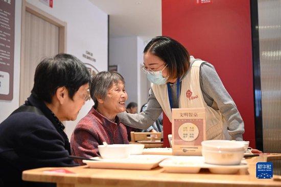 2023年11月16日，社区工作人员在福州市鼓楼区庆城社区长者食堂内与用餐老人交流。新华社记者 姜克红 摄