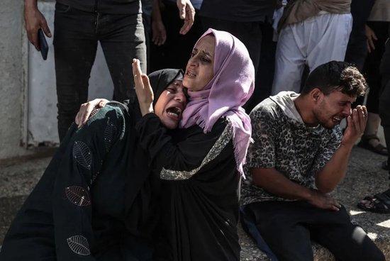 当地时间2023年10月7日，加沙城，在空袭中被以色列军队杀害的巴勒斯坦人的亲属被带到Shifa医院的停尸房后哀悼 / 图源：视觉中国