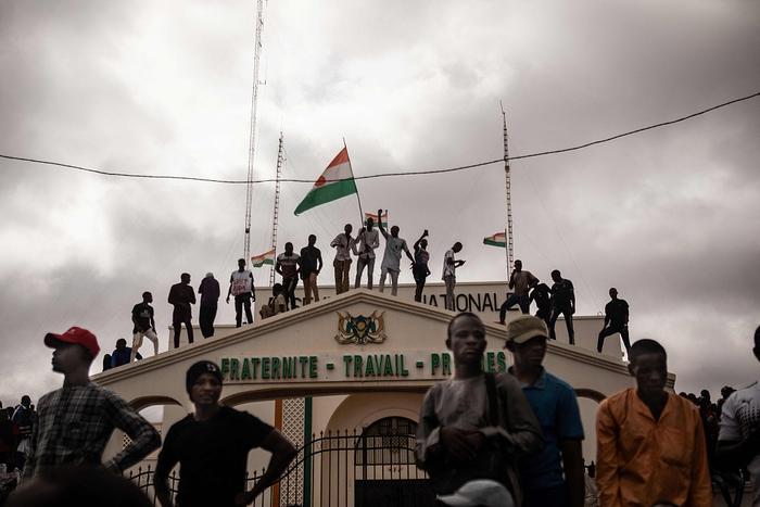 当地时间2023年8月3日，尼日尔尼亚美，抗议者在示威活动中举着尼日尔国旗。8月3日，数百名支持尼日尔政变的人聚集在首都尼亚美举行大规模集会。图片来源：视觉中国