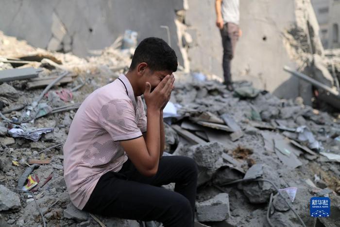11月2日，在加沙地带中部的布赖杰难民营，一名男子坐在以军空袭后的建筑废墟上哭泣。新华社发（亚西尔·库迪 摄）