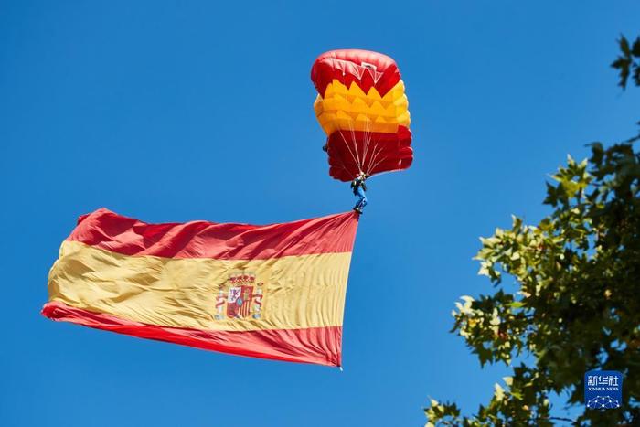 ▲资料图：2021年10月12日，一名伞兵在西班牙首都马德里的国庆日庆祝活动上展示国旗。图/新华社