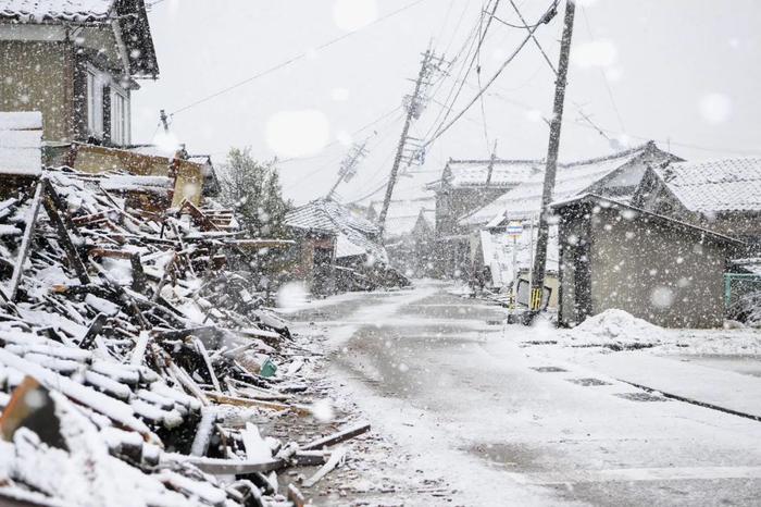 1月13日，日本石川县，在1月1日发生强震后，积雪覆盖着倒塌房屋。图/视觉中国