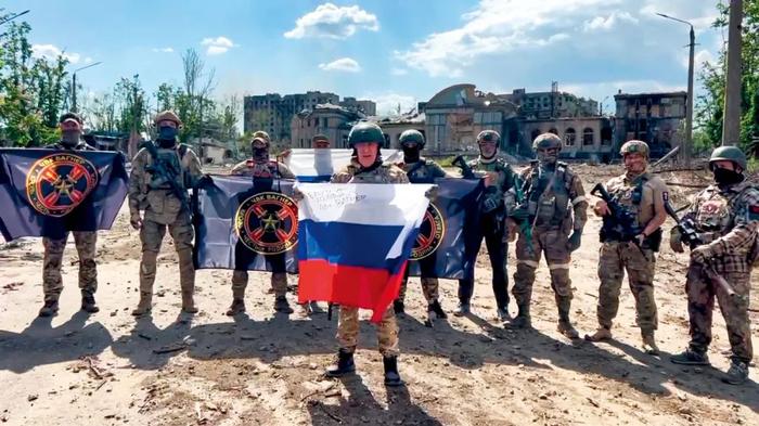 2023年5月20日，顿涅茨克地区巴赫穆特，普里戈任手持俄罗斯国旗在瓦格纳组织士兵面前讲话。
