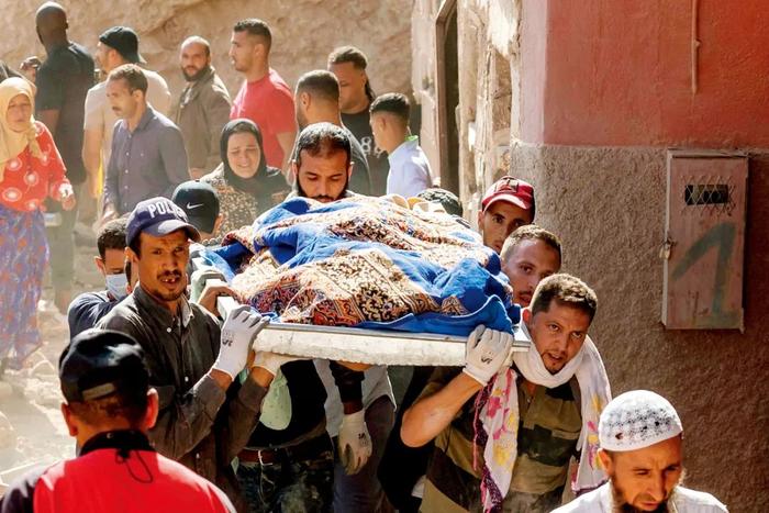 9月10日，摩洛哥马拉喀什，人们搬运遇难者的遗体。
