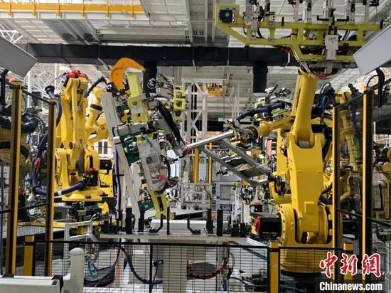 资料图：江西上饶的一家新能源电动汽车公司的智慧工厂内，机器人正同时作业。（文图无关）李韵涵 摄