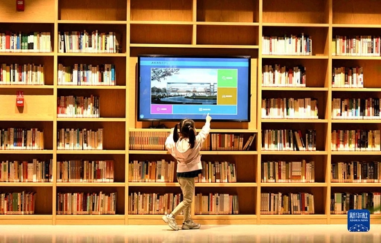 小朋友在位于正定新区的石家庄市图书馆新馆使用电子屏查阅书籍（2021年10月5日摄）。新华社发（许建园摄）