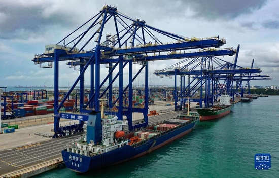 6月15日，集装箱货轮在海南洋浦国际集装箱码头装卸货物（无人机照片）。新华社记者 郭程 摄