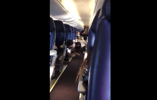 机舱内乘客躲避子弹（视频截图）