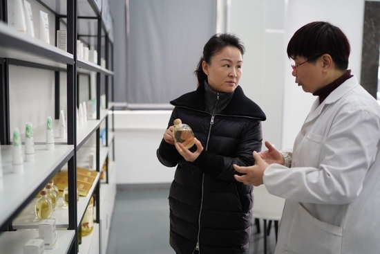 2月24日，明经华（左）在位于江西赣州市章贡区的赣州哈克生物科技有限公司调研油茶深加工产业。新华社记者 周密 摄
