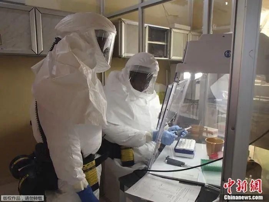 资料图：位于美国德特里克堡的美国陆军传染病医学研究所的技术人员，在一个遏制埃博拉病毒的实验室里进行化验。
