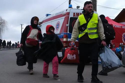  ▲2月28日，一名志愿者陪同来自乌克兰的人们离开波兰梅迪卡口岸。图/新华社