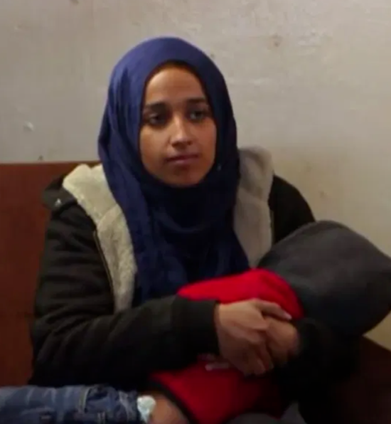 ·在叙利亚难民营，穆塔纳抱着儿子接受采访。
