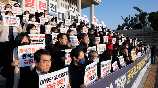 韩国国民议会大楼外，韩国民众反对政府就强征劳工问题提出的由第三方为日企代付赔偿金的方案。图源：ap