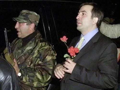  · 萨卡什维利（右）举着玫瑰。