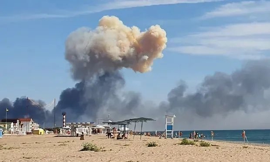从海滩上可以看到萨基空军基地爆炸产生的浓烟。图源：美联社