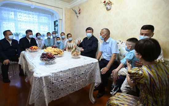 这是7月13日上午，习近平在乌鲁木齐市天山区固原巷社区，同维吾尔族居民阿布来提·吐尔逊一家人围坐在一起拉家常。