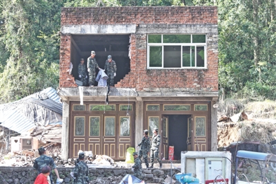 8月12日，温州永嘉山早村，武警在受灾损坏的房屋内进行清理。本版摄影/新京报记者 王嘉宁