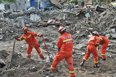8月12日，永嘉山早村，消防员在废墟中寻找失联人员。