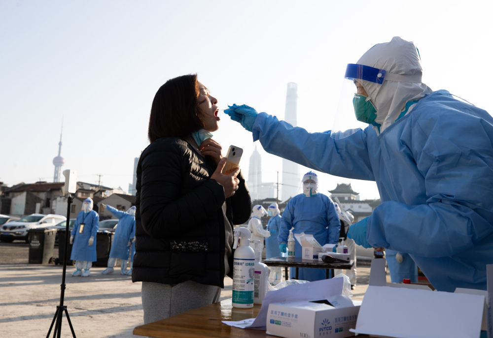 ↑4月4日，在上海市黄浦区豫园街道，工作人员为居民进行核酸检测采样。