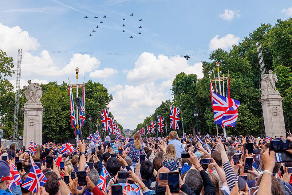 6月2日，在英国伦敦，人们在阅兵式后观看飞行表演。  新华社 发（蒂姆·爱尔兰 摄）