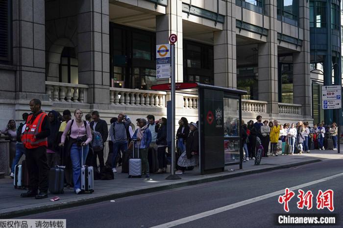 2022年6月21日，英国伦敦的一个公交站，由于地铁服务中断，人们在排队等待公交车。