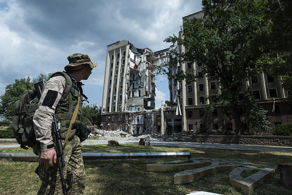 当地时间2022年8月5日，乌克兰尼古拉耶夫州，一名军人站在被摧毁的米柯莱夫地区军事行政大楼前。