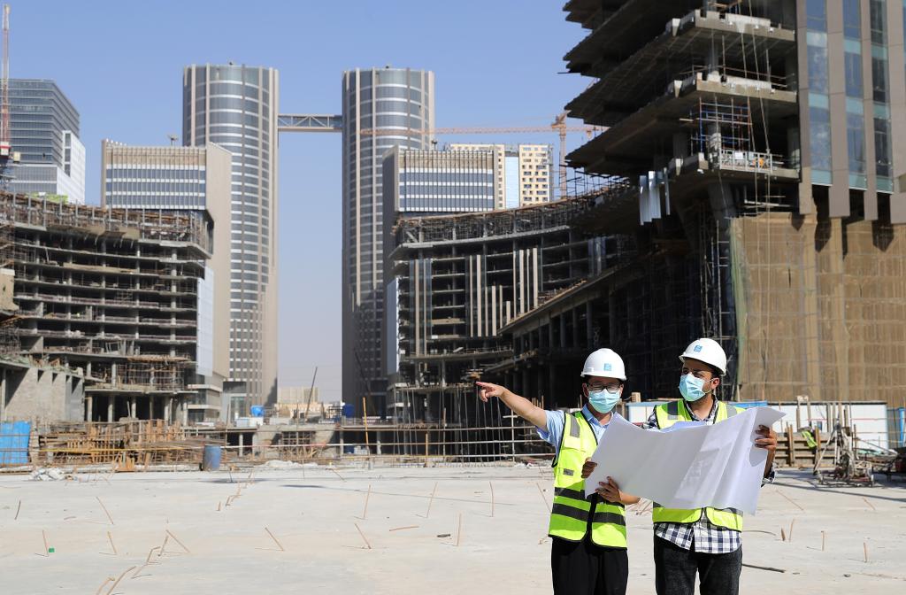 8月17日，埃方技术工程师瓦利德·拉马丹（右）和标志塔项目中方技术工程师陈柏宏在埃及新行政首都中央商务区项目现场工作。新华社记者王东震摄