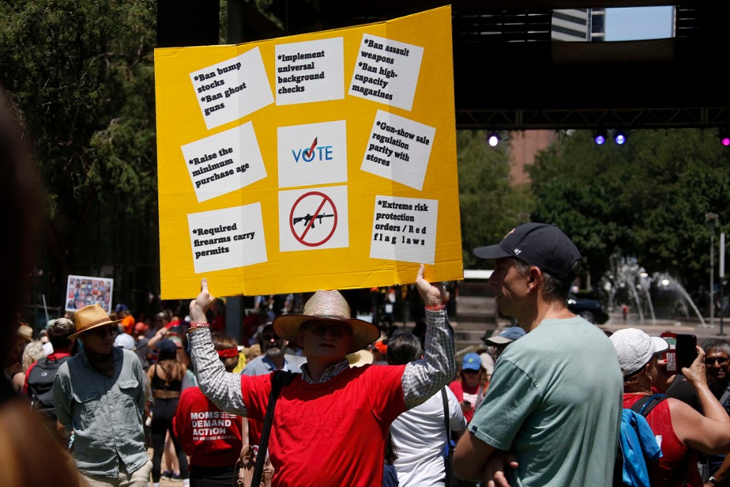 5月27日，在美国得克萨斯州休斯敦，一名参与者高举标语牌呼吁控枪。新华社发（劳承跃摄）