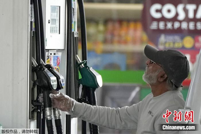 2022年6月9日，在伦敦的一个加油站，一名司机看着汽油泵。