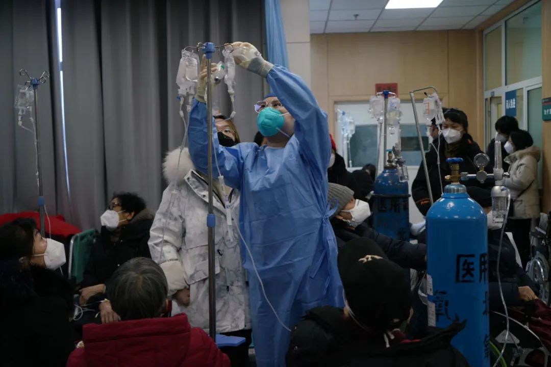  2022年12月27日，北京丰台，北京佑安医院急诊科输液大厅内，一名护士正在为患者换液。中青报·中青网记者李强/摄