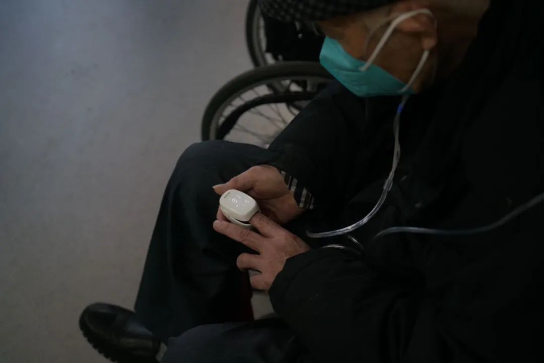 2022年12月27日，北京丰台，一名老人一边在医院急诊室吸氧，一边用指氧仪自测血氧饱和度，指氧仪显示，他当时的血氧饱和度为91%。中青报·中青网记者 李强/摄