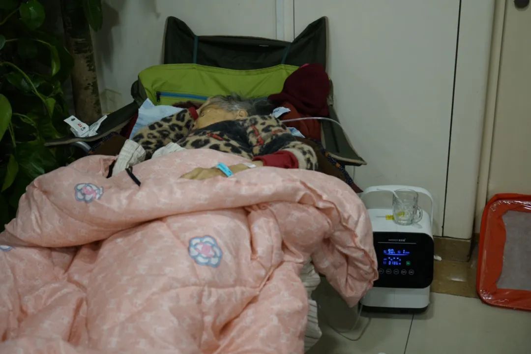 2022年12月21日，北京朝阳，一名老人躺在北京朝阳医院急诊科候诊区吸氧。中青报·中青网记者李强/摄