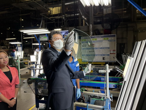 2022年9月7日，在福耀汽车玻璃生产基地，工人们邀请秦刚参观玻璃的配件安装工序。外交部网站 图