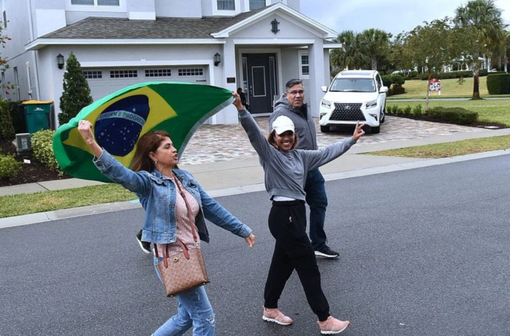 当地时间2023年1月13日，美国佛罗里达州，博索纳罗的支持者在其住所附近举起巴西国旗。图/视觉中国