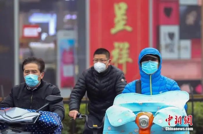  2月25日，戴着口罩骑车的市民在南京街头经过。 中新社记者 泱波 摄