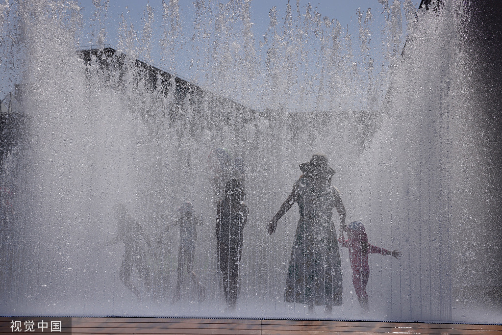 当地时间7月19日，英国伦敦，孩子们在伊丽莎白女王大厅外的喷泉里给自己降温。图源：视觉中国
