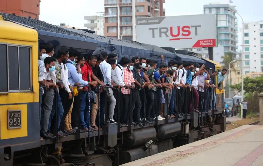 当地时间2022年7月6日，斯里兰卡首都科伦坡，一辆超载列车的发动机舱里，乘客们站在车上。由于斯里兰卡经济危机，燃料严重短缺，导致其他公共交通中断。（图|视觉中国）