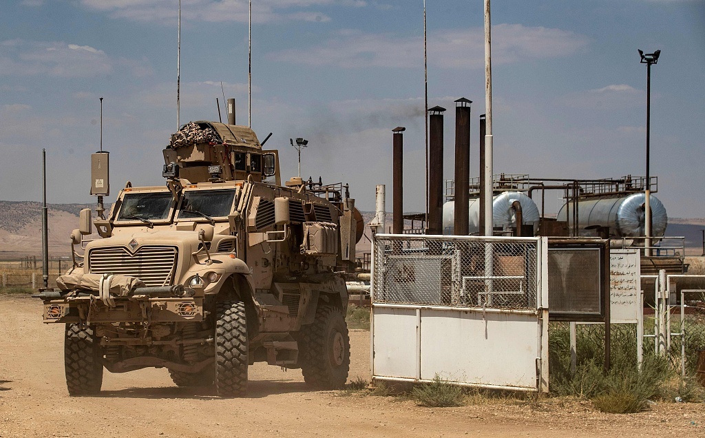 叙利亚东北部哈塞克省al-Qahtaniyah镇，美军士兵开车经过当地乡村的一个油田。图源：视觉中国