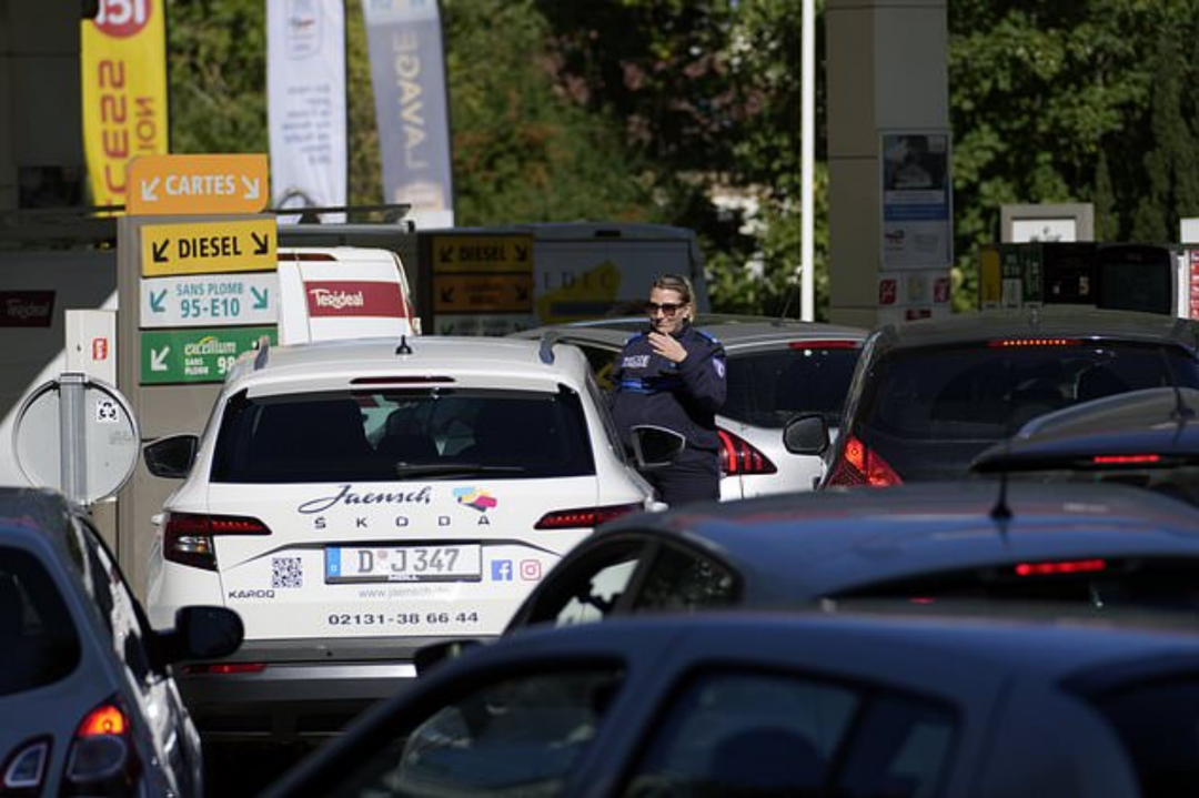 2022年 10 月 11 日，星期二，当司机在巴黎的加油站排队时，一名警察指挥汽车 图源：美联社